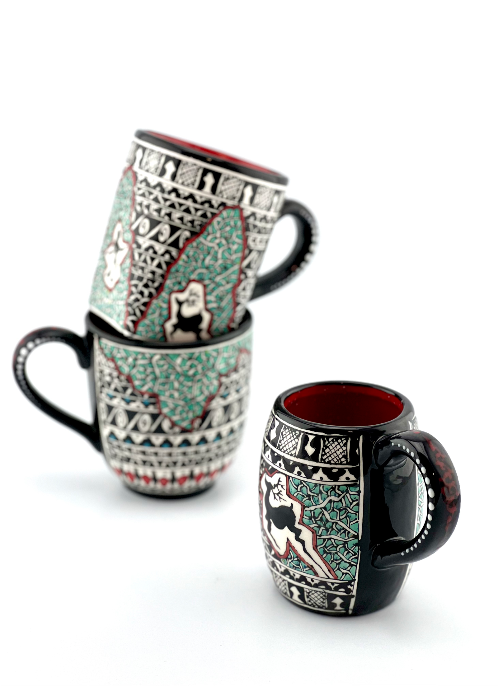 Close-up of hand-painted ceramic mugs with floral designs
