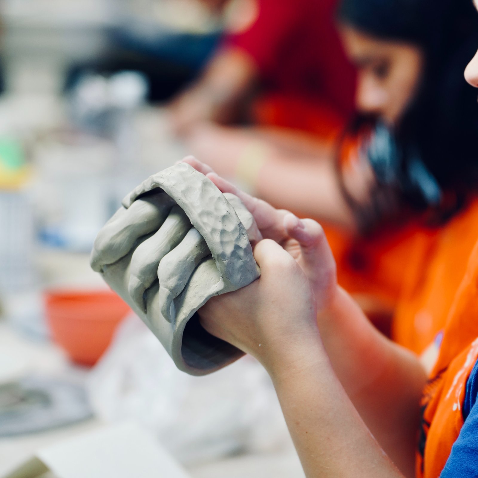 Close-up view of colorful glazes and pottery materials on a shelf
